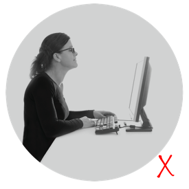 Dame med dårlig arbeidsstilling på grunn av progressive briller foran dataskjerm